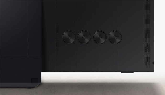 Detail čtyř kulatých reproduktorů integrovaných v zadní části televizoru, které doplňují elegantní design a zajišťují výkonný zvuk.